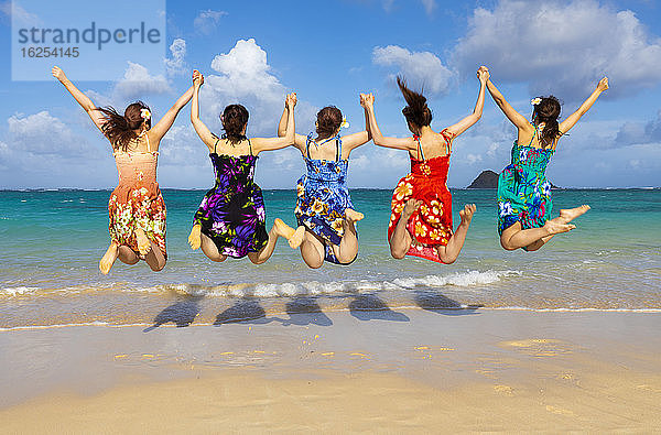 Eine Gruppe japanischer Studenten im Urlaub am Strand von Lanakai mit den Mokes-Inseln im Hintergrund: Oahu  Hawaii  Vereinigte Staaten von Amerika