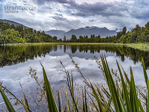 Lake Matheson ist ein kleiner See in Südwestland  Neuseeland  in der Nähe der Gemeinde Fox Glacier. Er ist berühmt für seine spiegelnden Ansichten von Aoraki/Mount Cook und Mount Tasman; Südwestland  Südinsel  Neuseeland