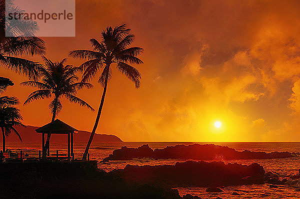 Dramatischer Sonnenaufgang über dem Uppers Beach Park mit einem glühenden Himmel  der sich rot über dem Pazifik spiegelt; Oahu  Hawaii  Vereinigte Staaten von Amerika
