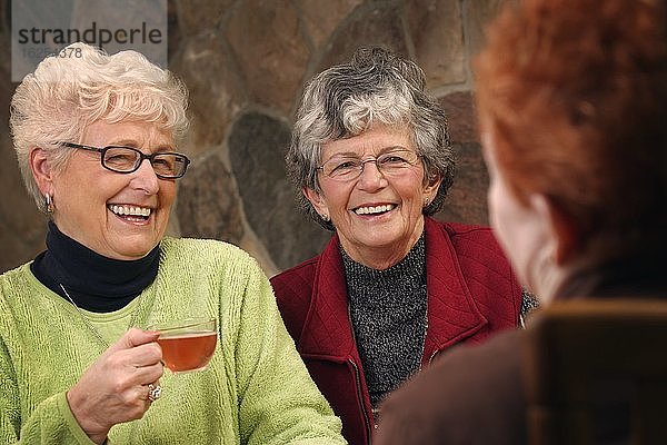 Drei ältere Damen diskutieren beim Tee.