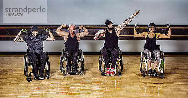 Eine Gruppe querschnittsgelähmter Freunde  die herumalbern und ihre Muskeln nach einem Training in einer Fitnesseinrichtung zeigen: Sherwood Park  Alberta  Kanada