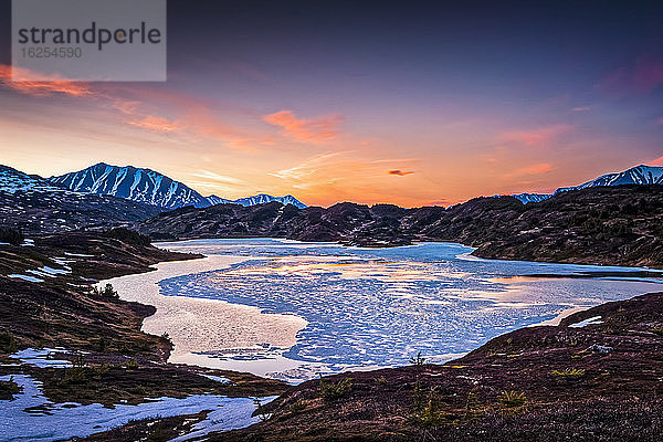 Halbverfrorener Verlorener See am Abend  im Hintergrund die Chugach-Berge. Chugach National Forest  Kenai-Halbinsel  Süd-Zentral-Alaska im Frühling; Seward  Alaska  Vereinigte Staaten von Amerika