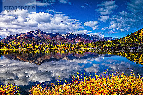 Gebirgskette spiegelt sich am Mentasta-See mit herbstlich gefärbtem Laub unter blauem Himmel  Tok vom Glenn Highway abgeschnitten  Süd-Zentral-Alaska im Herbst; Alaska  Vereinigte Staaten von Amerika