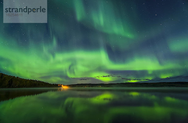 Leuchtend grünes Polarlicht tanzt mit Reflexionen über dem Birch Lake  Inneres Alaska im Herbst; Fairbanks  Alaska  Vereinigte Staaten von Amerika