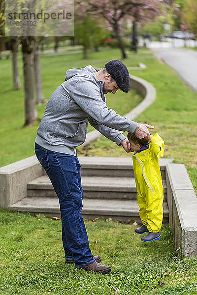 Vater spielt an einem Frühlingstag mit seiner Tochter im Park und hebt sie mit den Händen in die Luft; Surrey  Britisch-Kolumbien  Kanada