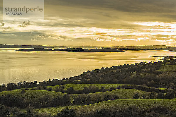 Grüne Felder und Landschaft mit Blick auf die Inseln an der Shannon-Mündung an einem bewölkten Tag bei Sonnenuntergang; Coney Island  Grafschaft Clare  Irland