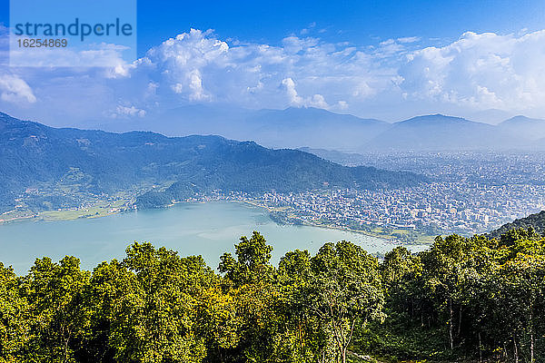 Blick über den Fewa-See auf die Stadt Pokhara  Nepal  an einem sonnigen Tag  Smog über der Stadt und den umliegenden Gebieten  an einem sonnigen Herbsttag; Pokhara  Kaski-Distrikt  Nepal