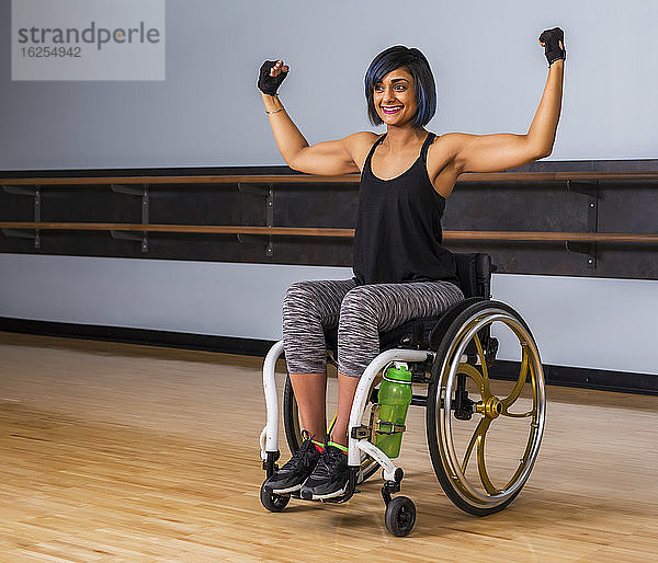 Eine querschnittsgelähmte Frau  die nach dem Training in einer Freizeiteinrichtung eine Pause in einer Turnhalle einlegt: Sherwood Park  Alberta  Kanada