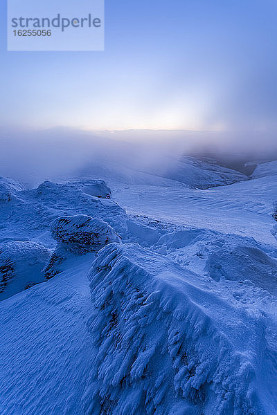 Schneebedeckte Felsen in den Galty-Bergen im Winter in der Morgendämmerung mit tief hängenden Wolken; Grafschaft Tipperary  Irland