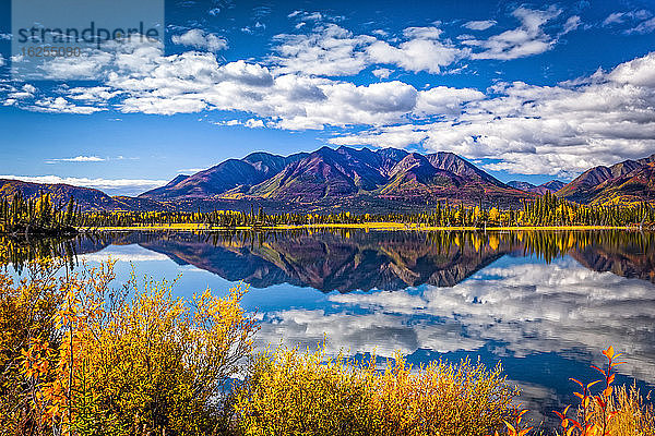 Gebirgskette spiegelt sich am Mentasta-See mit herbstlich gefärbtem Laub unter blauem Himmel  Tok vom Glenn Highway abgeschnitten  Süd-Zentral-Alaska im Herbst; Alaska  Vereinigte Staaten von Amerika