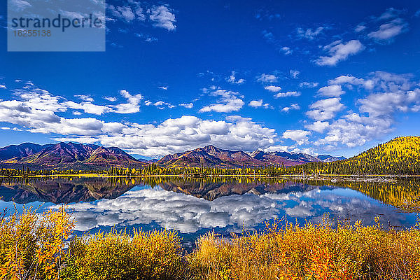 Gebirgskette spiegelt sich am Mentasta-See mit herbstlich gefärbtem Laub unter blauem Himmel  Tok vom Glenn Highway abgeschnitten  Süd-Zentral-Alaska im Herbst; Alaska  Vereinigte Staaten von Amerika