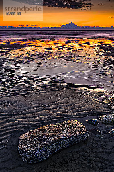 Mount Redoubt in der Abenddämmerung  Blick über den Cook Inlet. Bei Ebbe zeigte sich im Vordergrund ein welliges Wattenmeer  die Kenai-Halbinsel  Süd-Zentral-Alaska im Sommer; Ninilchik  Alaska  Vereinigte Staaten von Amerika