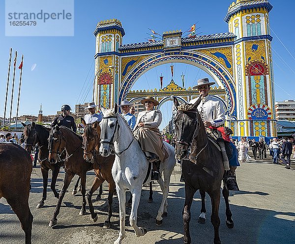 Reiter auf geschmückten Pferden in traditioneller Kleidung vor Eingangstor  Feria de Abril  Sevilla  Andalusien  Spanien  Europa