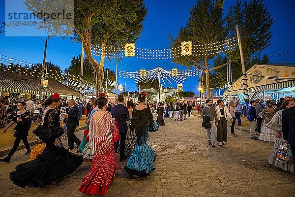 Spanische Frauen mit bunten Flamencokleidern  Abendstimmung  Feria de Abril  Sevilla  Andalusien  Spanien  Europa