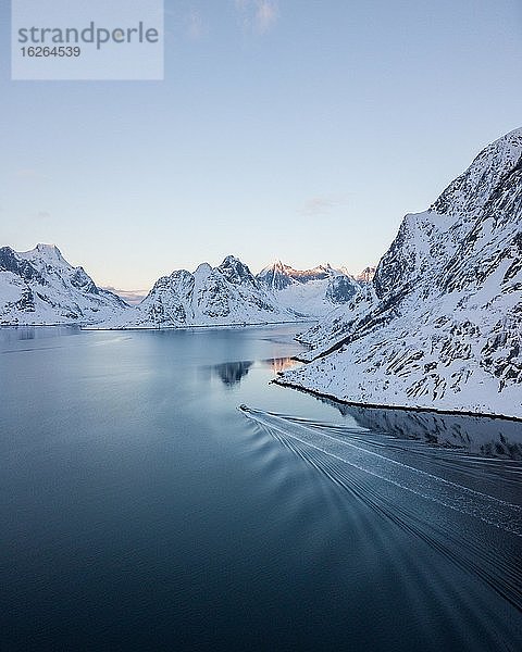 Luftaufnahme  Reinefjord mit verschneiten Bergen im Winter mit einem Fischkutter  Norwegen  Europa