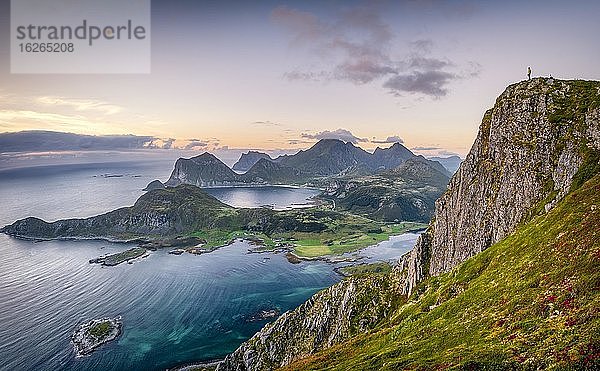 Winzige Person steht am Gipfel und blickt auf das weite Meer  hinten Lofotenberge  Offersoykammen  Leknes  Lofoten  Nordland  Norwegen  Europa