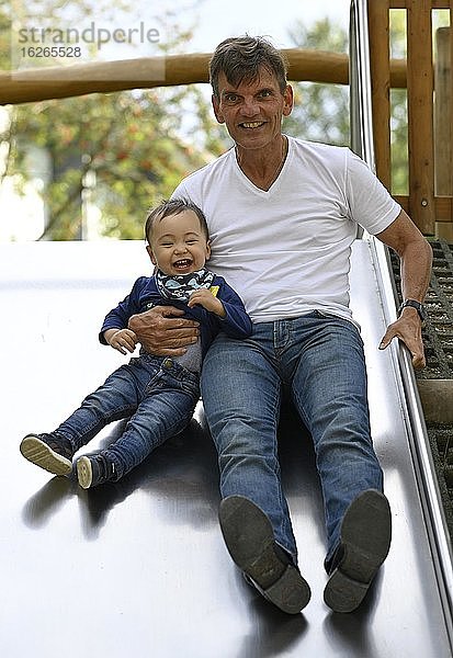 Kleinkind  Junge  14 Monate  multiethnisch  mit Großvater auf Rutsche  Blaubeuren  Baden-Württemberg  Deutschland  Europa