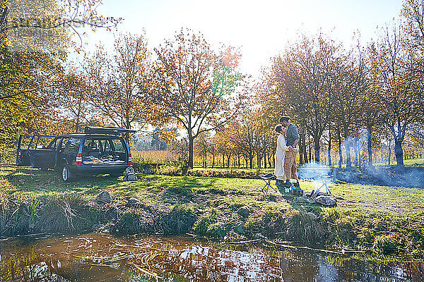 Liebevolles junges Paar zeltet im sonnigen Herbstfeld