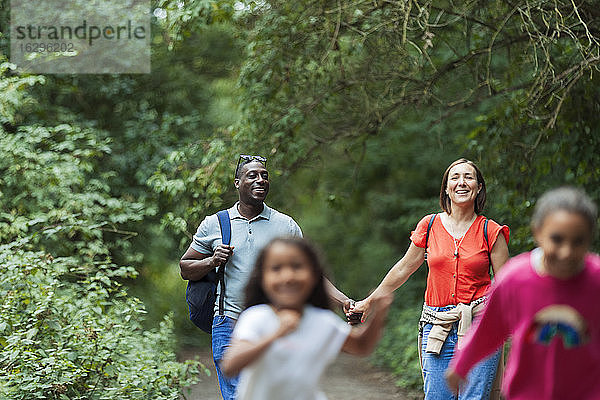 Glückliche Familie wandert auf Waldwegen