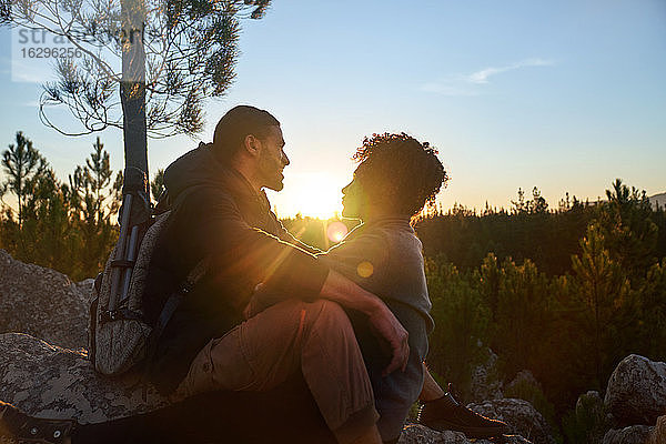 Liebenswertes junges Wanderpaar genießt ruhigen Sonnenuntergang im Wald