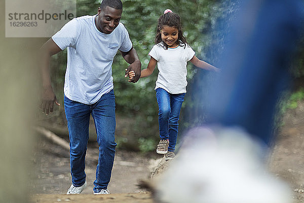 Glücklicher Vater und Tochter laufen im Wald