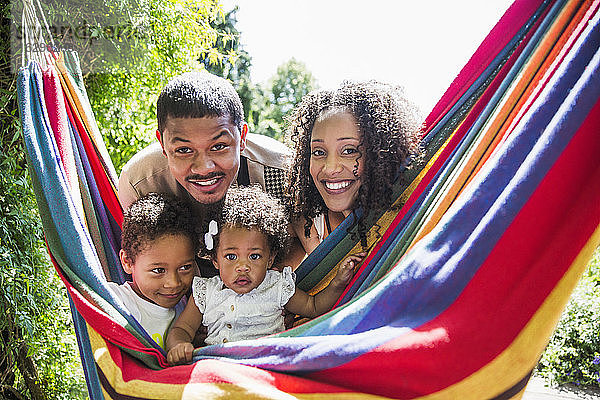 Portrait glückliche Familie in sonniger Sommerhängematte