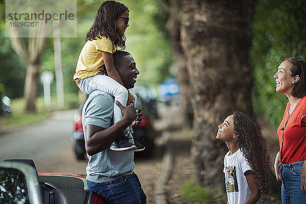 Glückliche Familie unterhält sich draußen im Cabrio auf der Straße