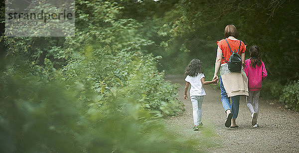 Mutter und Töchter wandern auf Waldwegen