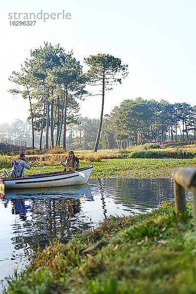 Junges Paar im Ruderboot auf einem sonnigen  ruhigen Teich