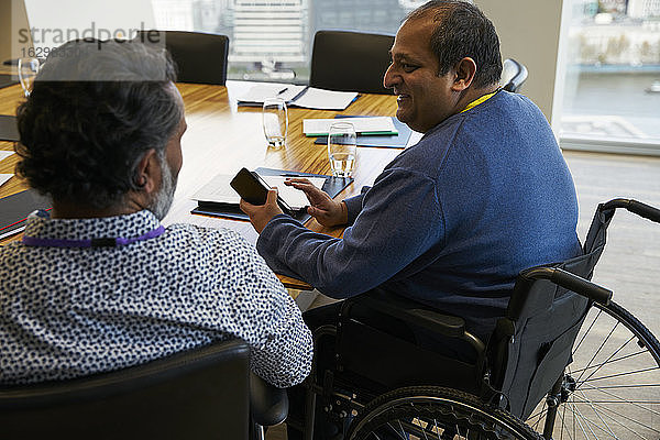 Geschäftsmann im Rollstuhl im Gespräch mit Sitzungskollege