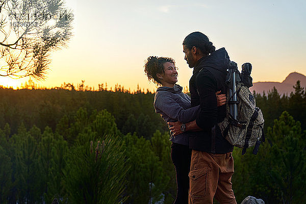 Zärtliches glückliches junges Wanderpaar in der Natur bei Sonnenuntergang