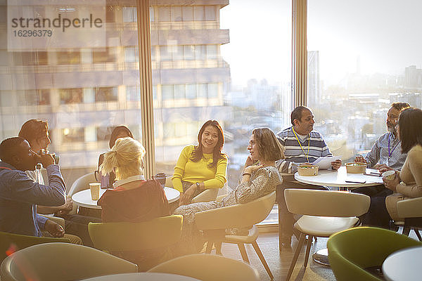 Geschäftsleute unterhalten sich und essen zu Mittag in der Hochhaus-Cafeteria