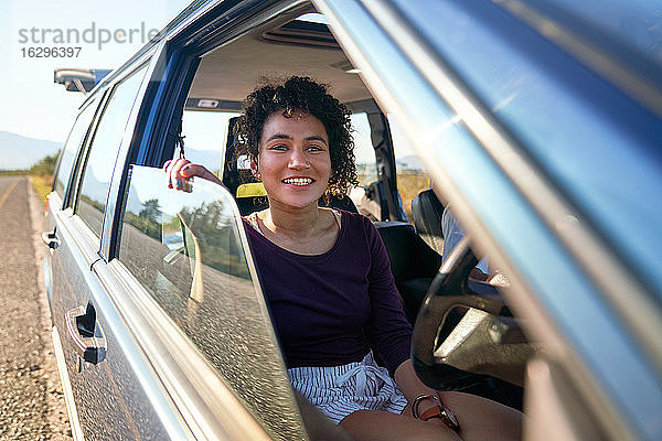 Glückliche junge Frau genießt Autoreise im Auto