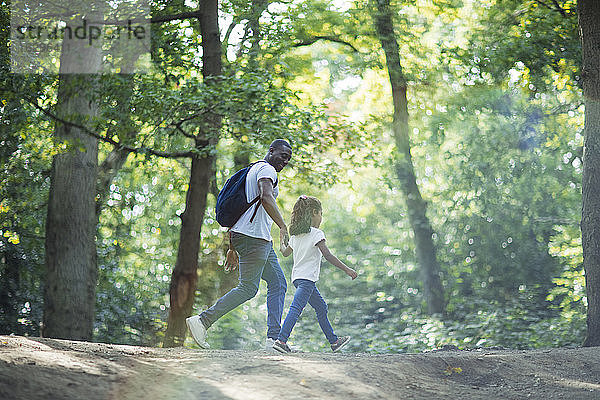 Vater und Tochter beim Wandern im Sommerwald