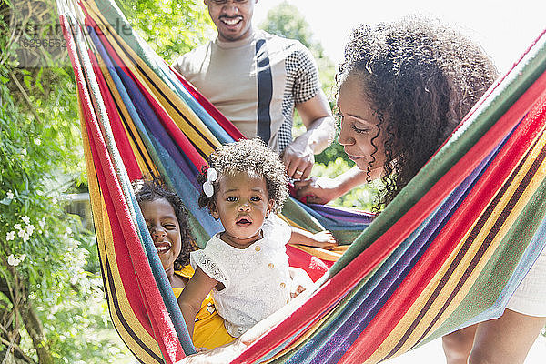 Porträt eines süßen Kleinkindes in sonniger Sommerhängematte mit Familie