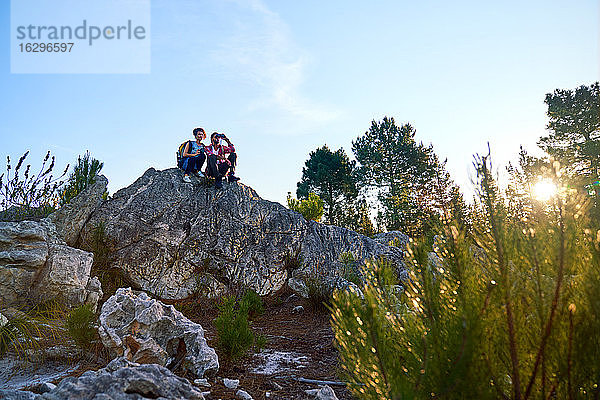 Junges Wanderpaar entspannt sich auf Felsen in sonniger Natur