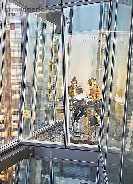Geschäftsleute treffen sich am Fenster eines modernen Hochhausbüros