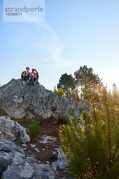 Junges Paar mit Fernglas auf Felsen in der Natur