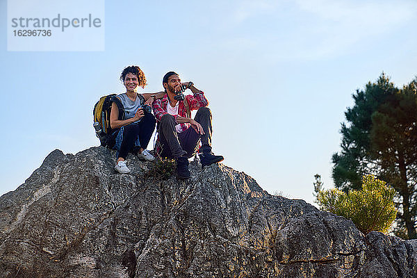 Glückliches junges Wandererpaar entspannt sich am Fels