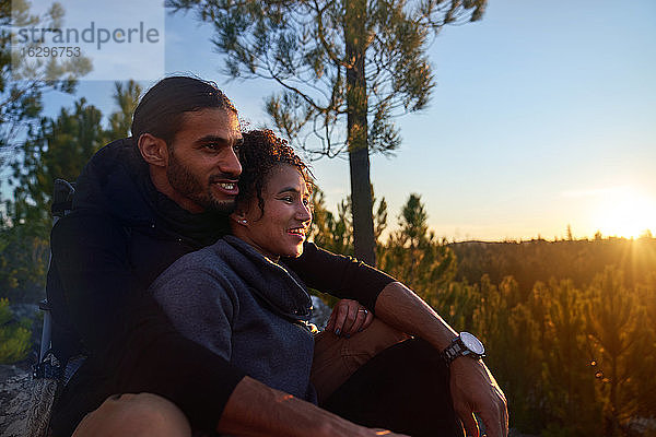 Liebenswertes junges Wandererpaar genießt Sonnenuntergang im Wald