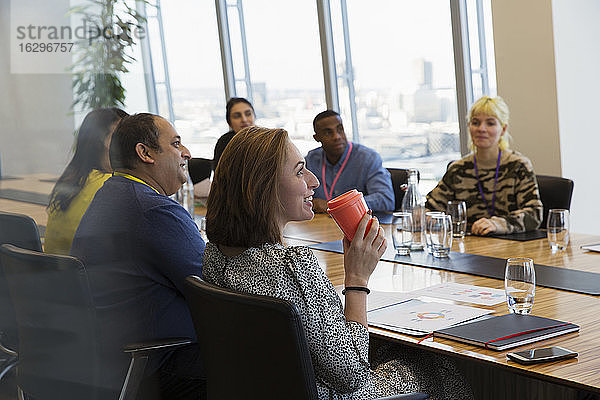 Lächelnde Geschäftsfrau trinkt Kaffee im Konferenzraum