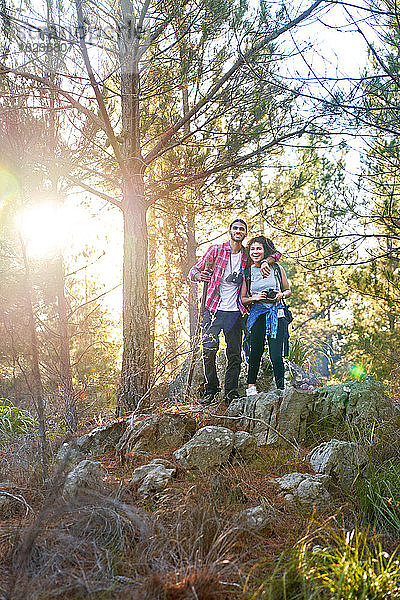 Glückliches junges Paar wandert in sonnigen Wäldern