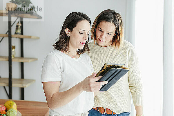 Freunde lernen zu Hause auf einem digitalen Tablet über Ernährung