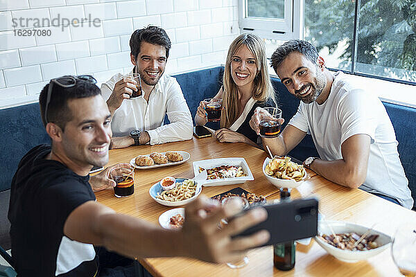 Gruppe von Freunden  die ein Selfie machen  während sie im Restaurant essen