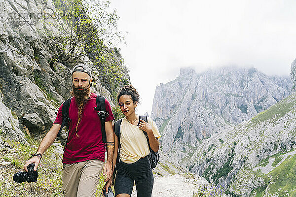 Wanderer mit Kamera in der Hand beim Wandern auf einem Bergpfad an der Ruta Del Cares  Asturien  Spanien