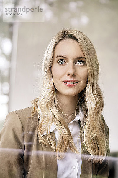 Nahaufnahme einer nachdenklichen Unternehmerin mit blondem Haar  die im Büro wegschaut