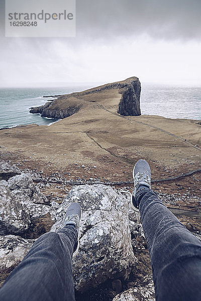 UK  Schottland  Beine eines Mannes auf Felsen am Neist Point sitzend