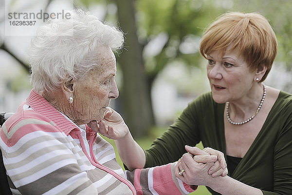 Deutschland  Nordrhein-Westfalen  Köln  Seniorin hält Hände einer reifen Frau  Nahaufnahme