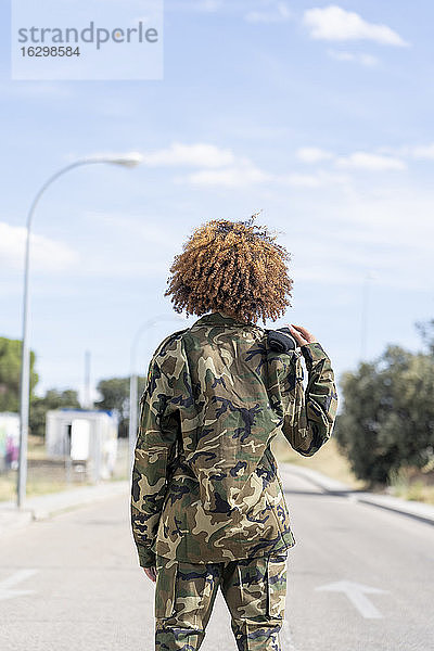 Weiblicher Militäroffizier steht an einem sonnigen Tag auf der Straße