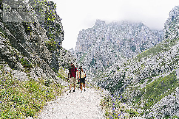 Mann und Frau wandern gemeinsam auf einem Bergpfad an der Ruta Del Cares  Asturien  Spanien
